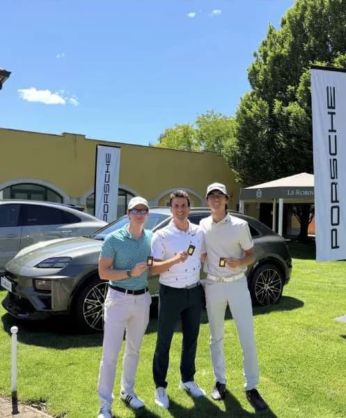 I tre di Bravo Golf mostrano i lingotti Investi in Oro davanti a un'auto, a Le Robinie