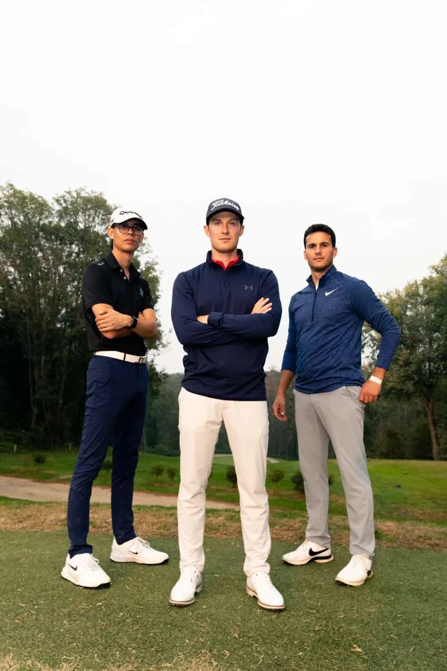 Matteo, Andrea e Simone in piedi sul campo, di sera, con le braccia incrociate